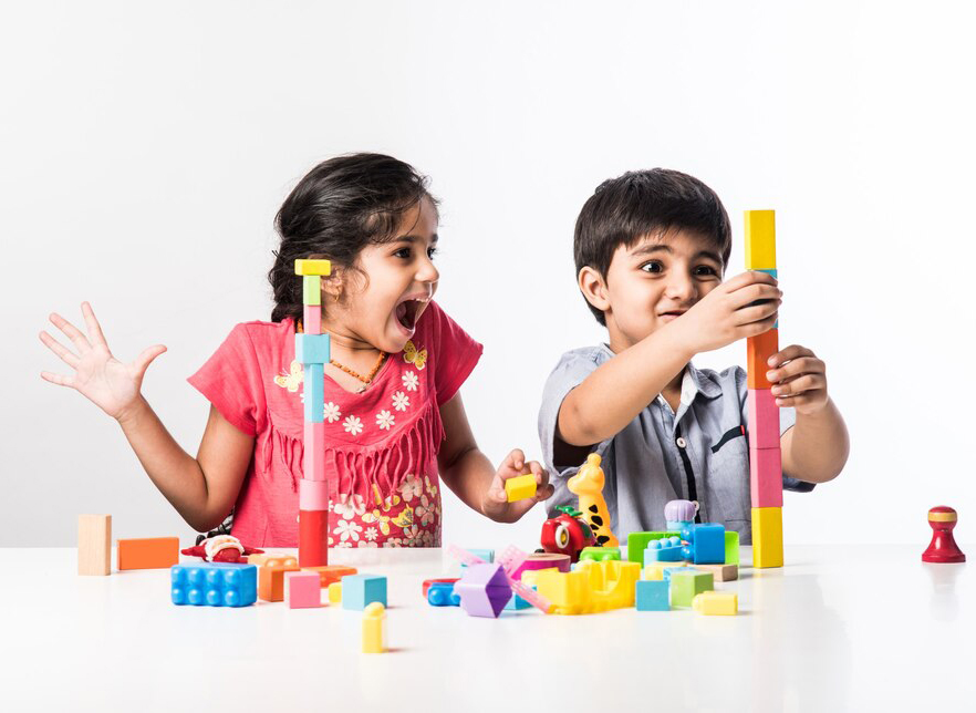 2 kids playing with K square edutainment Montessori items