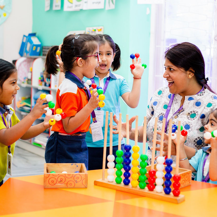 A teacher demonstrating abacus usage to children in a classroom setting.