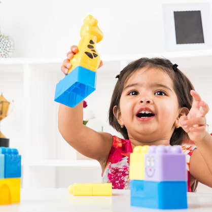 A young girl happily building with colorful K square edutainment Lego blocks, showcasing her creativity and imagination.