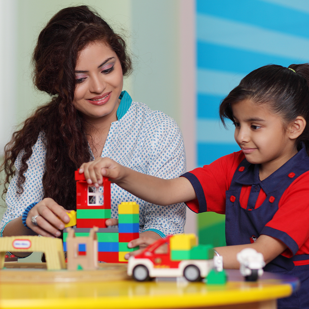 A young boy happily playing with colorful K square edutainment  balls in a basket.